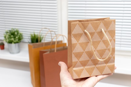 Three paper shopping bags on white office table, online trading and and delivery concept.