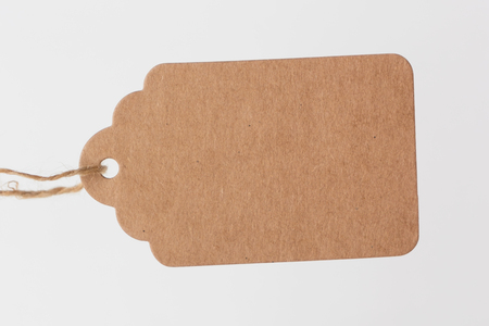 Brown cardboard label, tag with slim rope cord on white background.の写真素材