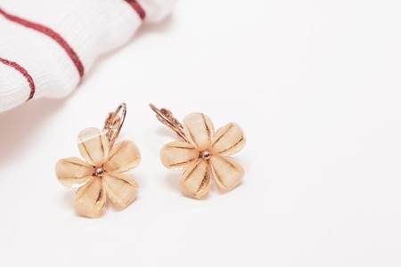 A pair of cristal flower form bijouterie earrings on white background with copy space.