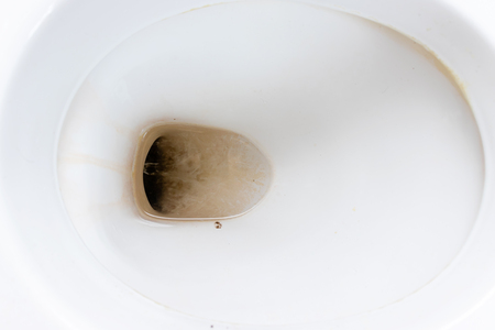 Dirty unhygienic toilet bowl with limescale stain at public restroom close up.の写真素材