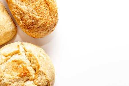 Assortment, different kinds of wheat baked bread with golden crust on white background with copy...