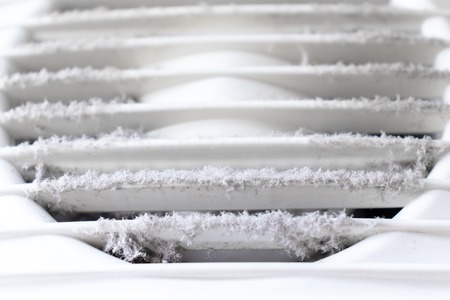 Extremely dirty and dusty white plastic ventilation air grille at home close up, harmful for health.の写真素材