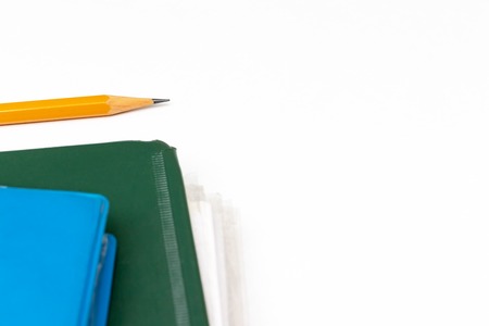 Cropped colorful folders with documents and bills and a yellow pencil on white table with copy...
