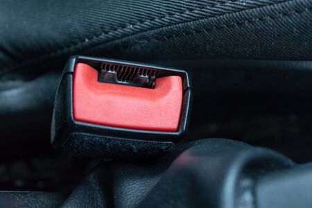 Red button of safety belt, seatbelt in a car close up, car safety and driver protection concept.