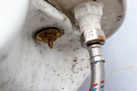 Water supply fitting of cistern tank of the toilet bowl at water closet close up.