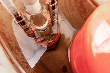 Dirty unhygienic rusty and calcified flush tank of toilet with limescale and rust stains and scum close up need to be cleaned and repared.の写真素材