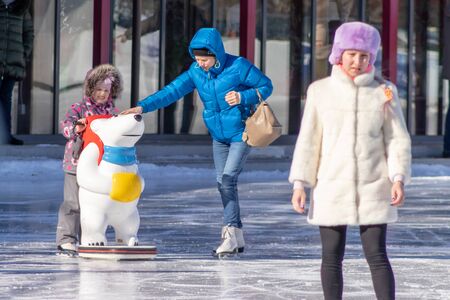 MOSCOW, RUSSIA- MARCH 02, 2019: People wearing winter clothes skating on a winter skating rink, family leisure and sport activity on christmas vacations and holidays.のeditorial素材