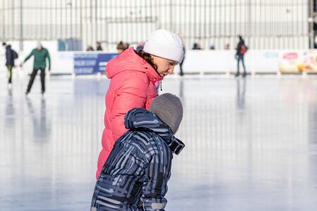 MOSCOW, RUSSIA- MARCH 02, 2019: Woman teaching her child to skate on a winter skating rink, family leisure and sport activity on christmas vacations and holidays.のeditorial素材