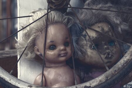 Creepy sinister old broken dirty abandoned dolls as halloween concept.の写真素材