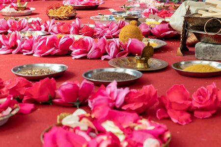 Indian wedding ceremony, decorations for traditional ethnic rituals for marriage, fire burning, flowers and statuettes of the deity on red carpet.の写真素材