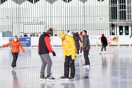 MOSCOW, RUSSIA- MARCH 02, 2019: People wearing winter clothes skating on a winter skating rink, family leisure and sport activity on christmas vacations and holidays.のeditorial素材