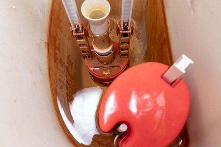 Dirty unhygienic rusty and calcified flush tank of toilet with limescale and rust stains and scum need to be cleaned and repared.の写真素材