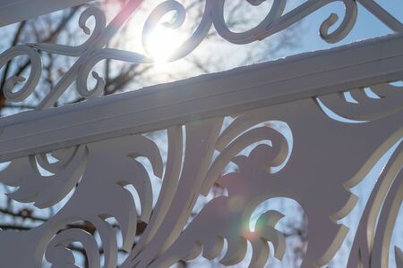 Detail of white painted wooden carved fence on sunny day.の写真素材
