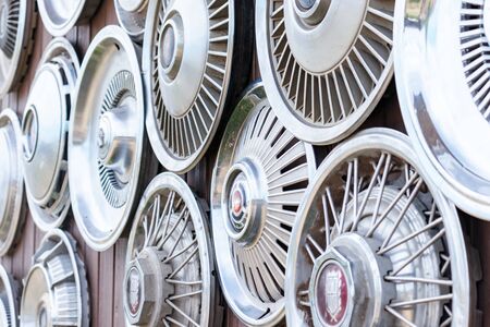 Moscow, Russia - August 11, 2019: Wall collection of vintage rusty automobile hubcaps of retro cars.のeditorial素材