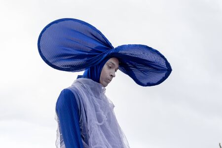 Moscow, Russia - September 14, 2019: Clown festival in the city, clown in colorful blue clothes, big hat and with a bright makeup communicates with children and makes emotional face.のeditorial素材
