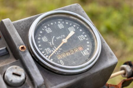 Retro motorcycle black analog speedometer close up.