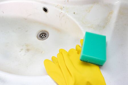 Concept of cleaning old dirty washbasin with rust stains, limescale and soap stains in the bathroom.の写真素材