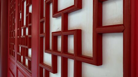 Red wooden carved decorative doors in chinese style, asian traditional ornament for decorating home, walls and doors.の写真素材