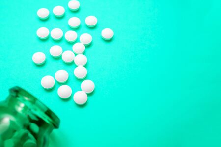 A glass bottle of antiviral pills tablets capsules against coronavirus causing pneumonia on blue...