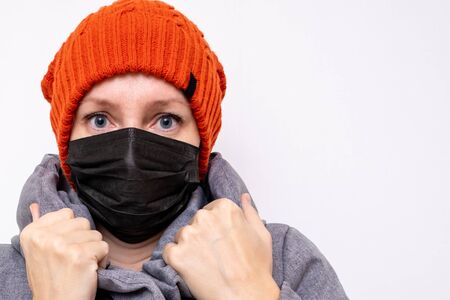 Concept of coronavirus quarantine. Woman in winter clothes and a black respiratory medical surgical mask as a protection from viruses and bacteria.の写真素材