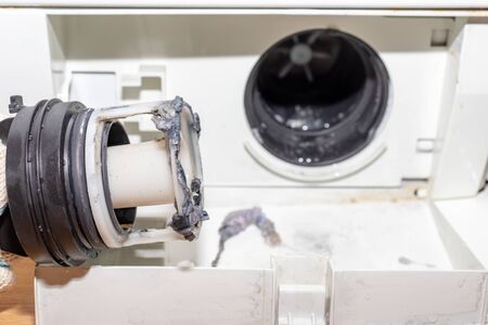 Broken pump of washing machine's caused by dirty clogged drain pump filter close up, clean and repair.の写真素材