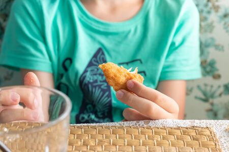 A hungry preteen boy eating chicken nuggets in a restaurant.の写真素材