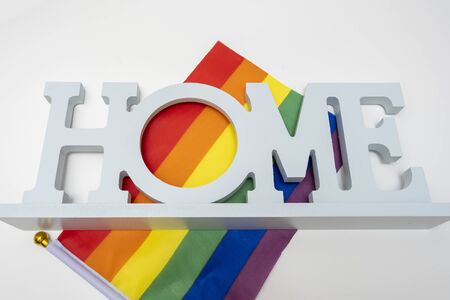 Lgbt rainbow gay pride flag and a sign home on white backgroundの写真素材