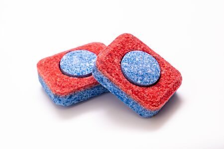 two red dishwasher soap tablet on white background.の写真素材