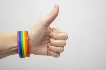 A finger up hand wearing lgbt rainbow gay pride bracelet.の写真素材