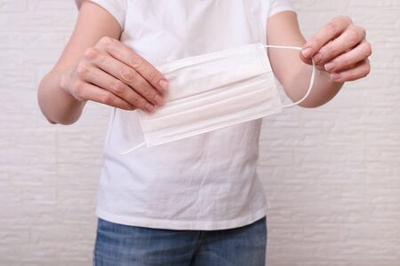 Woman holding white surgical medical mask ,face mask in hands to show personal protective equipment...