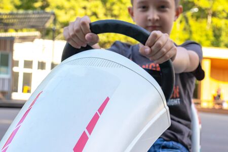 A boy riding four wheel bike, pedal cart, go-kart rented in entertainment park in summer, children urban activities concept.の写真素材