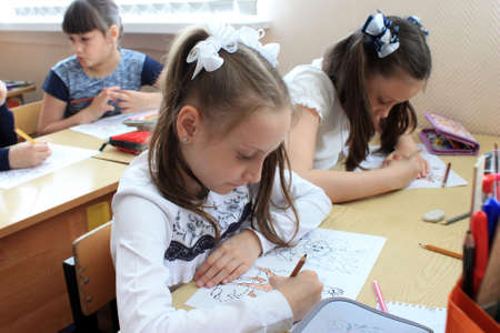 Moscow, Russia - September 1, 2017: Schoolgirls sitting at the desk in class at school, traditional learning, offline education form, Day of knowlege in Russian school.のeditorial素材