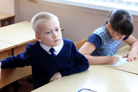Moscow, Russia - September 1, 2017: Schoolboy, pupil sitting at the desk in class at school, traditional learning, offline education form, Day of knowlege in Russian school.のeditorial素材