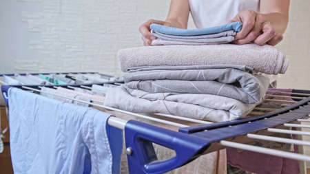 Woman housewife doing housework, she take care of linen and clothes, washing and drying it