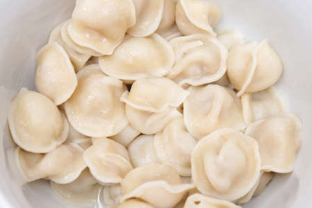 Traditional tasty boiled russian pelmeni, ravioli, dumplings with meat on white ceramic plate on gray background.の写真素材