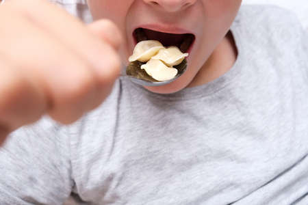 A hungry teen teenager boy eating dumplings close up at home, convenience and rapid cooking food concept.の写真素材