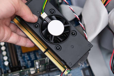 Hand of a tachnician, rapairman holding part of a computer needed to be replaced or upgraded.