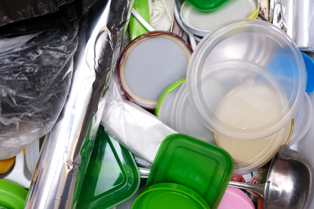 A lot of plastic waste in a kitchen drawer, plastic containers and kitchenware in mess, recycling conceptの写真素材
