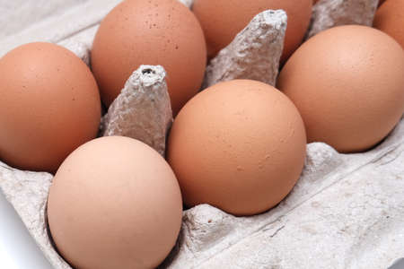 Brown eggs in recycled carton pressed box container close up