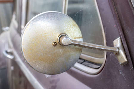 Side mirror of old abandoned rusty vehicles, crushed cars in scrapyard, junk yard needed to be utilised and reused to protect nature and environment, metal recycling conceptの写真素材
