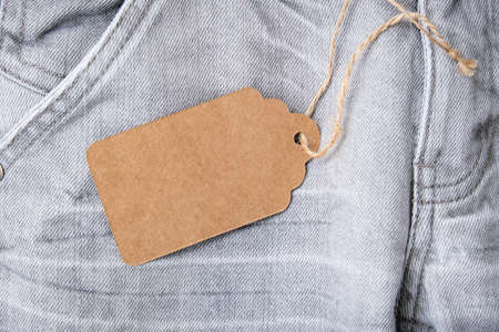 Craft blank label on gray shabby jeans background, sale and discount conceptの写真素材