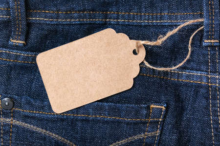 Craft blank label on dark blue jeans background, sale and discount concept.の写真素材