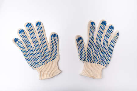 Construction worker protective knitted dotted gloves on white background, hand protection and safety...
