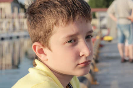 A boy is sitting on an embankment of a resort city, he is upset because all theatres and museums are...