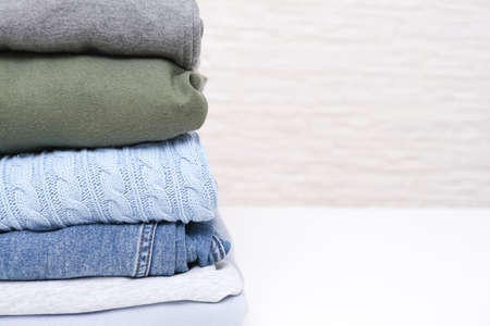 Folded stacked warm winter and autumn casual clothes close up with copy spaceの写真素材