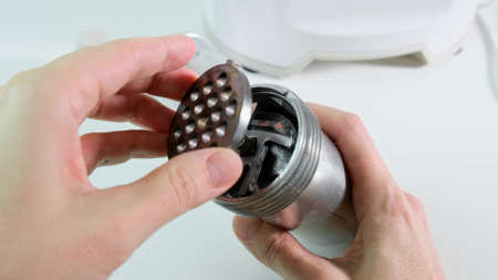 Woman hands assembling modern electric meat grinder, mincer for making minced meatの写真素材