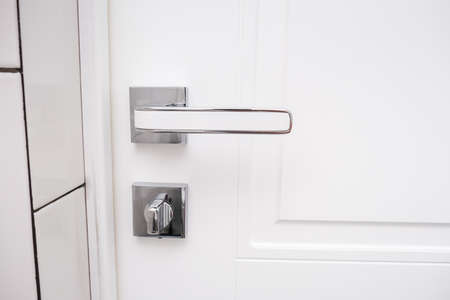White wooden door with a chrome handle and safety security knob for privacy protectionの写真素材