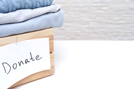 Wooden box full of old used clothes for donation and charity, recyclind and reusing clothes, copy spaceの写真素材