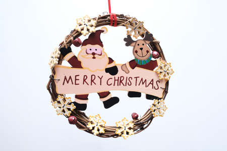 Plain holiday wreath with Merry Christmas sign on white backgroundの写真素材