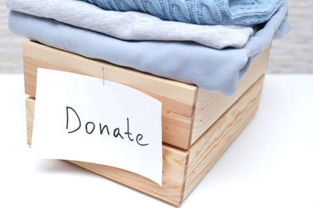Wooden box full of old used clothes for donation and charity, recyclind and reusing clothesの写真素材